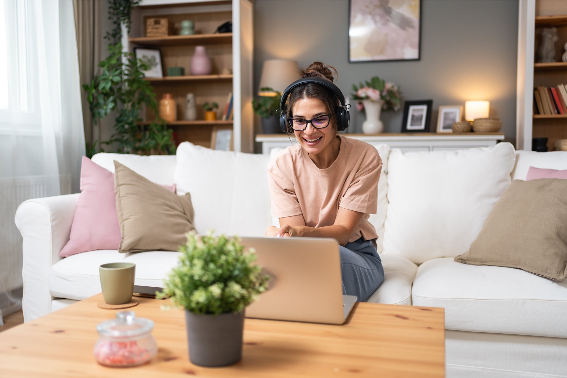 Mujer con auriculares usando un portátil